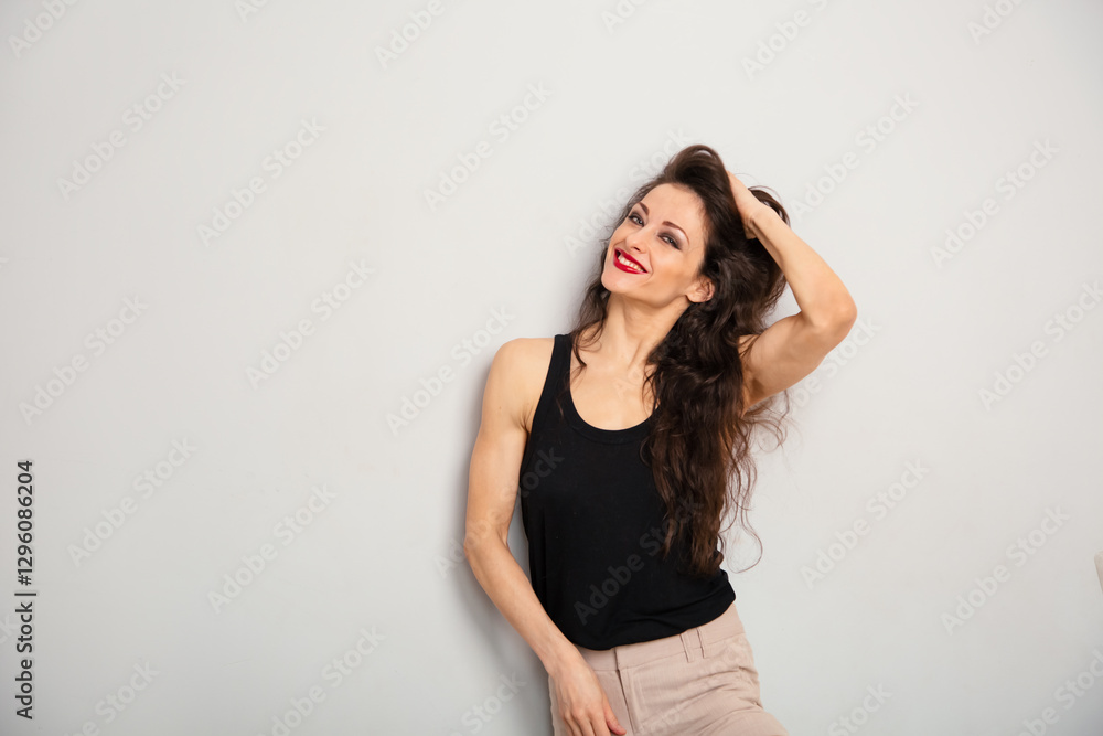 Happy enjoying relaxing make-up woman with red lipstick looking happy and holding her hand her brown long hair in black top on blue studio empty copy space background. Expression portrait Happy enjoying relaxing make-up woman with red lipstick looking happy and holding her hand her brown long hair in black top on blue studio empty copy space background. Expression portrait