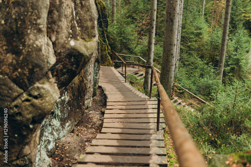 Obraz na płótnie The wooden stairs lead up a steep slope. Boardwalk trail through the forest and rocks. Rock city in Adrspach, Czech Republic w salonie