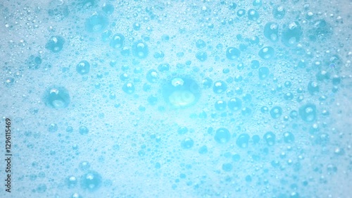 Soap suds in water, bubbles float and burst Abstract white soap foam texture. Concept of cleaning and washing.