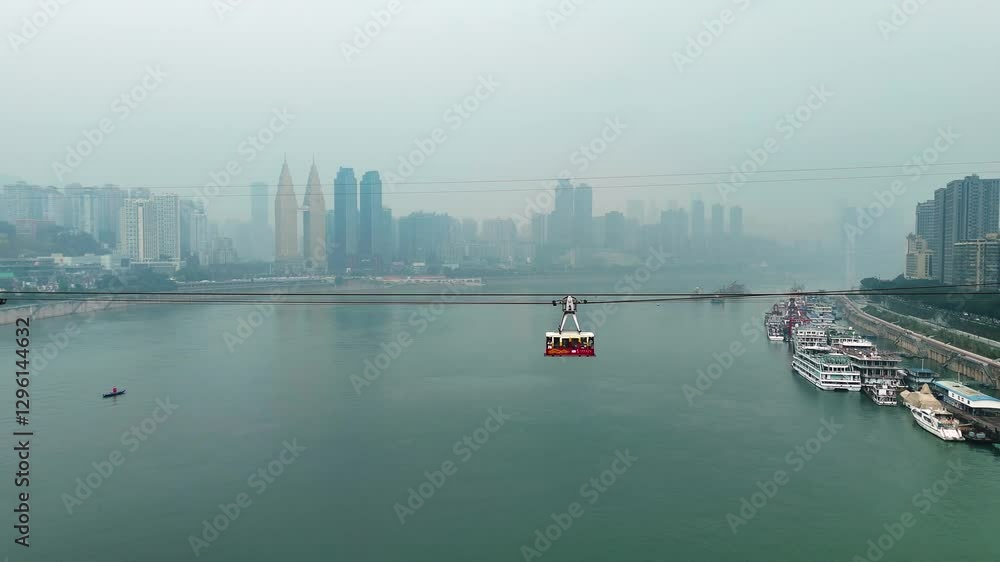 Aerial view following a cable car cabin above the river in Chongqing, China, showcasing the city’s skyline and the stunning landscape from a unique perspective during daytime. Aerial view following a cable car cabin above the river in Chongqing, China, showcasing the city’s skyline and the stunning landscape from a unique perspective during daytime.