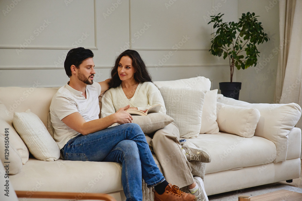 Cozy couple reading together on a comfortable sofa at home