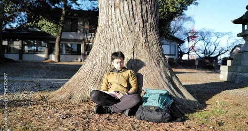 Wallpaper Mural Japanese man in his 30s sitting in front of a large tree and taking a break Torontodigital.ca