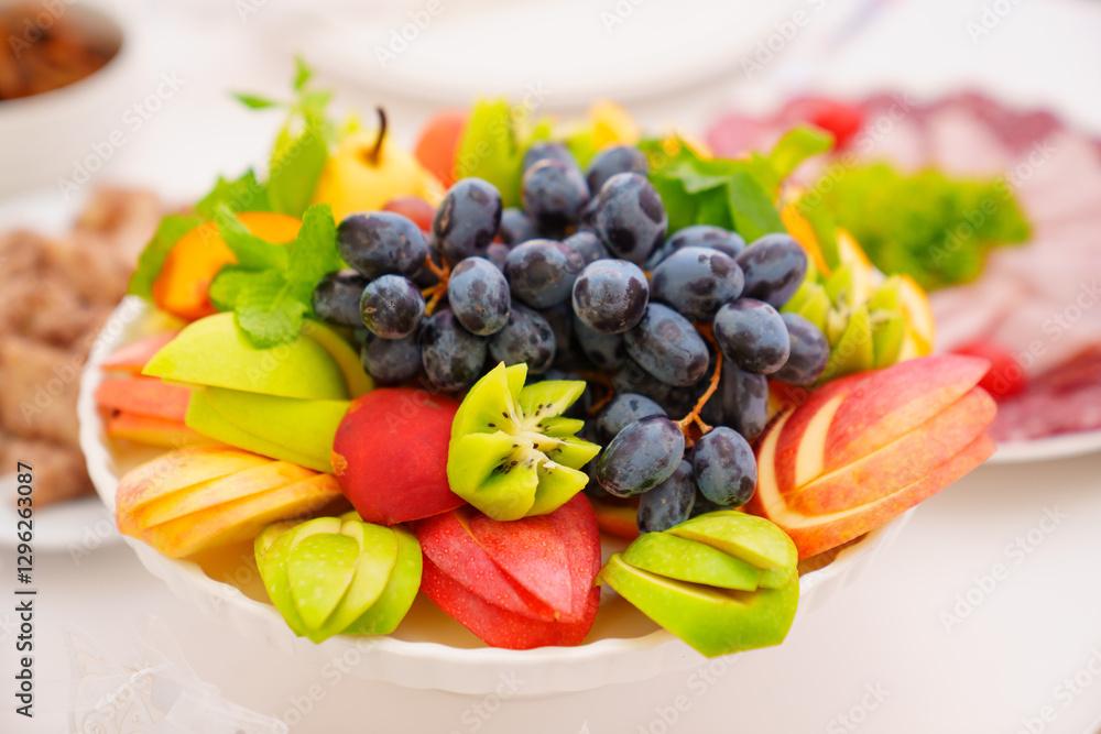Fruit plate with grapes, kiwi, apple and mint. A healthy and delicious dessert.