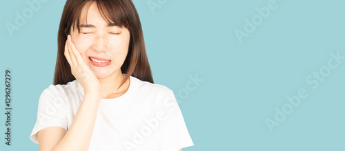 Fényképezés Asian woman suffering from toothache or jaw pain over blue background