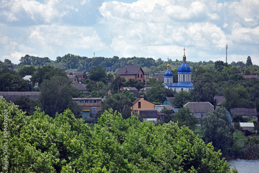 church. view of the Ukrainian church in the village. religion, Christianity. church holidays. crosses on the domes. no people. roofs of houses. summer or spring time. Orthodox temple.