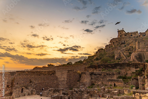 Obraz na plátně A magnificent full view of Golconda Fort in Hyderabad during sunset, with the golden hues of the sky casting a warm glow over the historic fortress