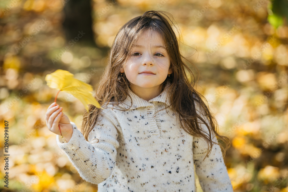 A cheerful little girl plays and frolics in the park. The concept of joyful childhood emotions, stylish clothing, and fashion trends.