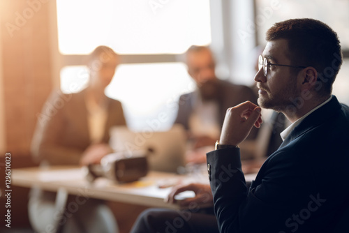 Photography Business professional in deep thought during a meeting, sitting in a modern office