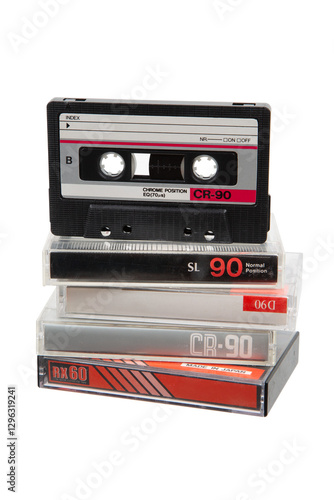 Stack of vintage audio cassettes, black and silver, in clear cases, retro 90s media, nostalgic tech.