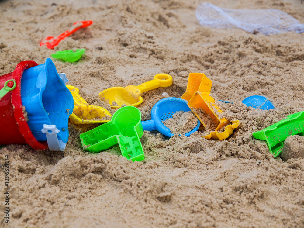 Colorful beach sand play toys - bucket, scoop, sand and sand mold in green, red, blue and yellow Colorful beach sand play toys - bucket, scoop, sand and sand mold in green, red, blue and yellow