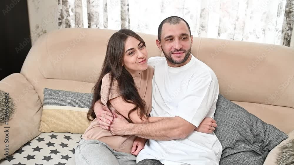Loving couple hugging family cuddling intimately on plush sofa, exchanging tender glances during romantic valentine's celebration Loving couple hugging family cuddling intimately on plush sofa, exchanging tender glances during romantic valentine's celebration