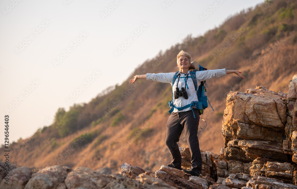 Senior woman is hiking outdoors, enjoying nature expression looks into the distance observing and possibly guide trekking and trail ecotourism adventure concept.