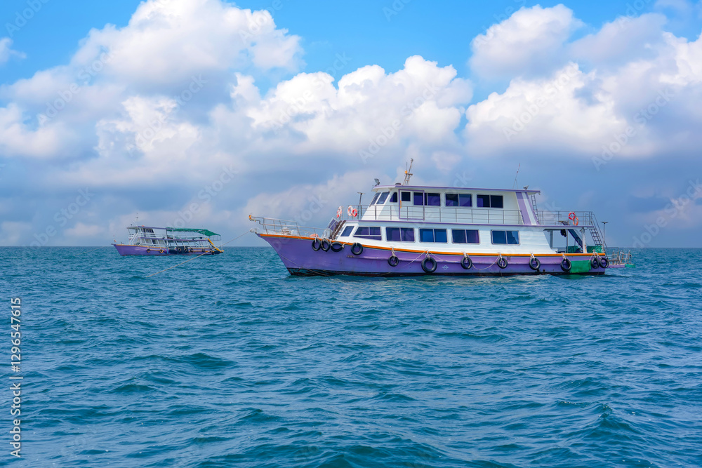 Two colorful boats float gently on clear blue waters, surrounded by a bright sky filled with fluffy clouds. The scene captures a peaceful coastal moment in daylight. Two colorful boats float gently on clear blue waters, surrounded by a bright sky filled with fluffy clouds. The scene captures a peaceful coastal moment in daylight.
