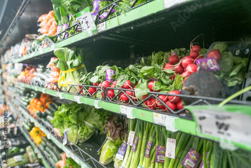 vegetables on the supermarket counter. Onions and parsley with lettuce and radishes. photo
