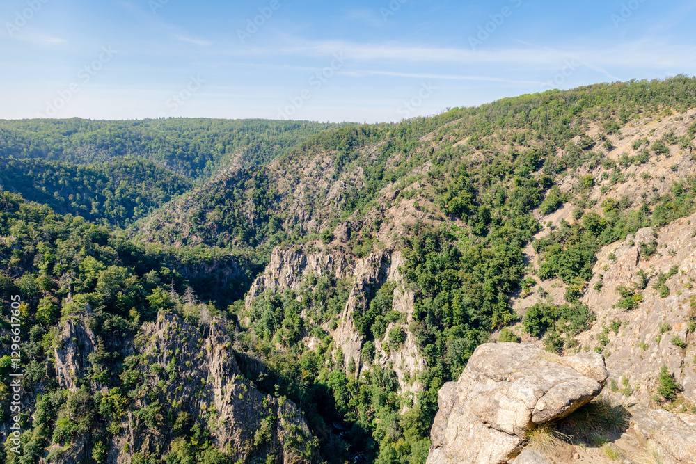 Fototapeta premium The 403-metre-high granite crag Rosstrappe in the Harz Mountains in Germany is a popular viewpoint and can be reached by foot or chair lift. It offers views of the Witch Dance Square and Bode Valley.