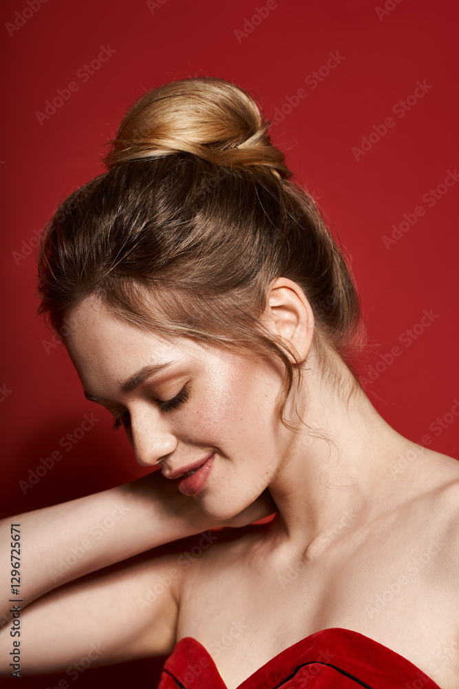 Fototapeta premium Stunning young woman showcasing elegant style against a vibrant red backdrop