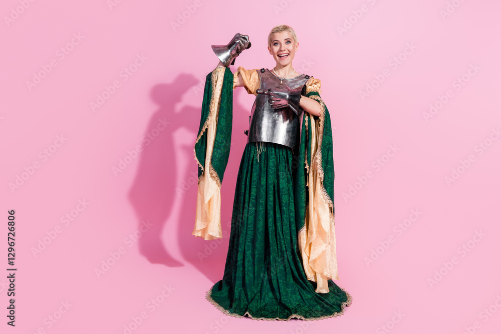 Young woman in medieval attire holding armor against a pink background, combining classic and historical styles Young woman in medieval attire holding armor against a pink background, combining classic and historical styles