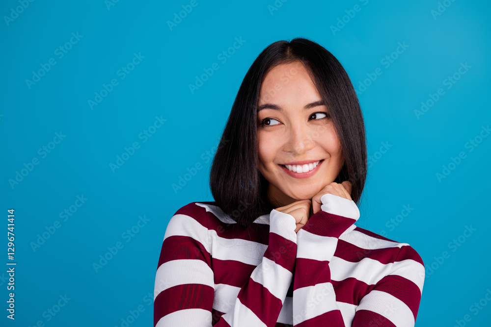 Smiling Young Woman in Trendy Striped Shirt Against Bright Blue Background Smiling Young Woman in Trendy Striped Shirt Against Bright Blue Background
