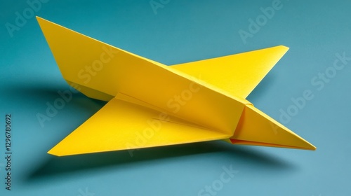 Free Download Bright Yellow Paper Airplane on Blue Surface for Creative Projects - GFXLoad