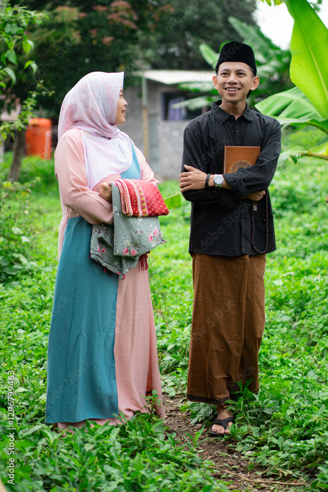 Muslim male students and Muslim female students wearing hijabs walk together carrying the Koran, the concept of Ramadan and Eid al-Fitr, Muslim religious holidays. Muslim male students and Muslim female students wearing hijabs walk together carrying the Koran, the concept of Ramadan and Eid al-Fitr, Muslim religious holidays.