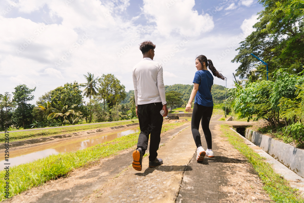 Obraz premium back view of active asian couple walking exercise at rural area