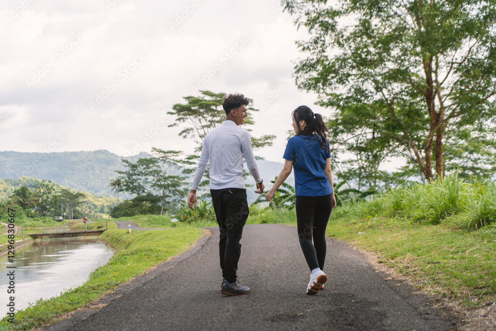 back view of active asian couple walking exercise at rural area back view of active asian couple walking exercise at rural area