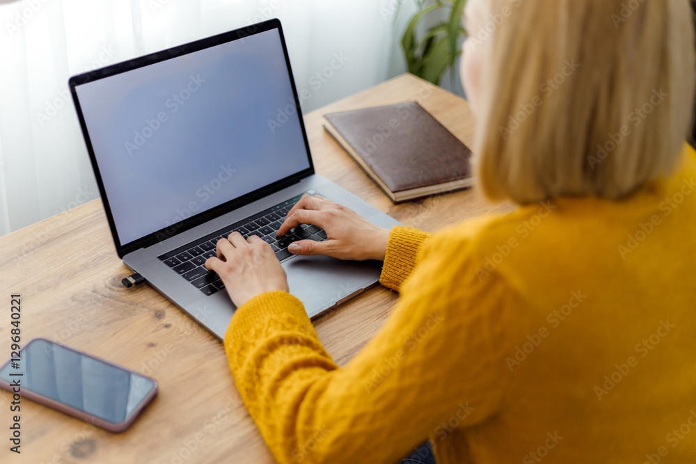 Person using laptop at home workspace during day Person using laptop at home workspace during day