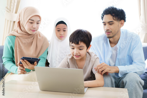 Asian muslim family relaxing in living room together.