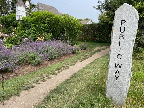 A stone pillar marks the path of a public walkway, passing a garden in Siasconset, on Nantucket Island