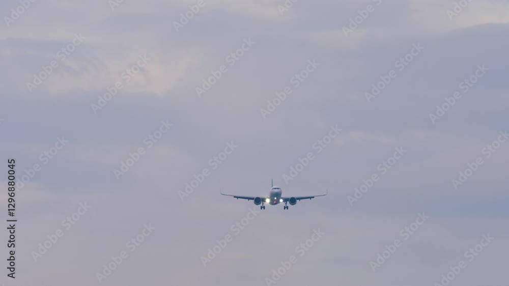Commercial airplane approaching landing, long shot, front view. Passenger flight arriving. Travel concept Commercial airplane approaching landing, long shot, front view. Passenger flight arriving. Travel concept