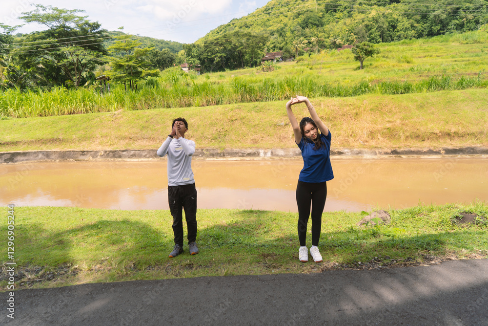 active young asian couple stretching before exercising at rural area active young asian couple stretching before exercising at rural area