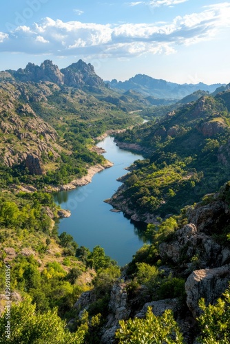 Serene river winding through mountain valley on sunny day for travel, nature