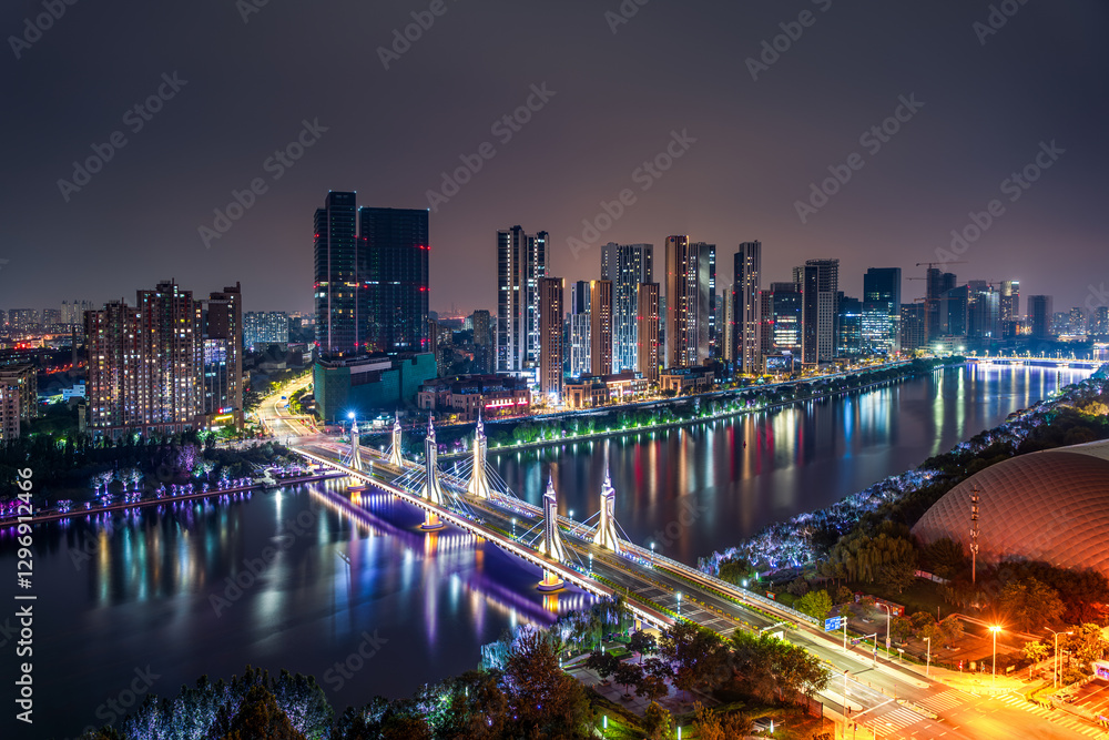 Fototapeta premium The urban river in Tongzhou, Beijing, China, and the high-rise buildings on both sides of the river under the night view