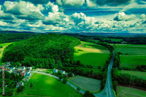 Obraz na płótnie Vibrant German Village Nestled in a Valley Surrounded by Lush Greenery and Picturesque Mountains on a Bright Sunny Day w salonie