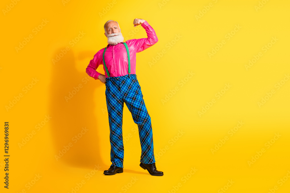 Full size photo of old gentleman confident pose flexing muscle dressed glamour stylish outfit party isolated vibrant yellow background Full size photo of old gentleman confident pose flexing muscle dressed glamour stylish outfit party isolated vibrant yellow background