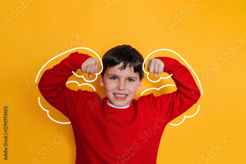 Strong child boy in a painted superhero costume on yellowe. Children's confidence, struggle with complexes, self-esteem.
