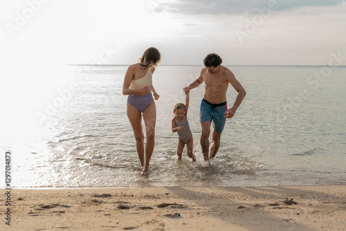 Quadro em tela Family enjoys a sunny day at the beach while playing in the shallow water togeth