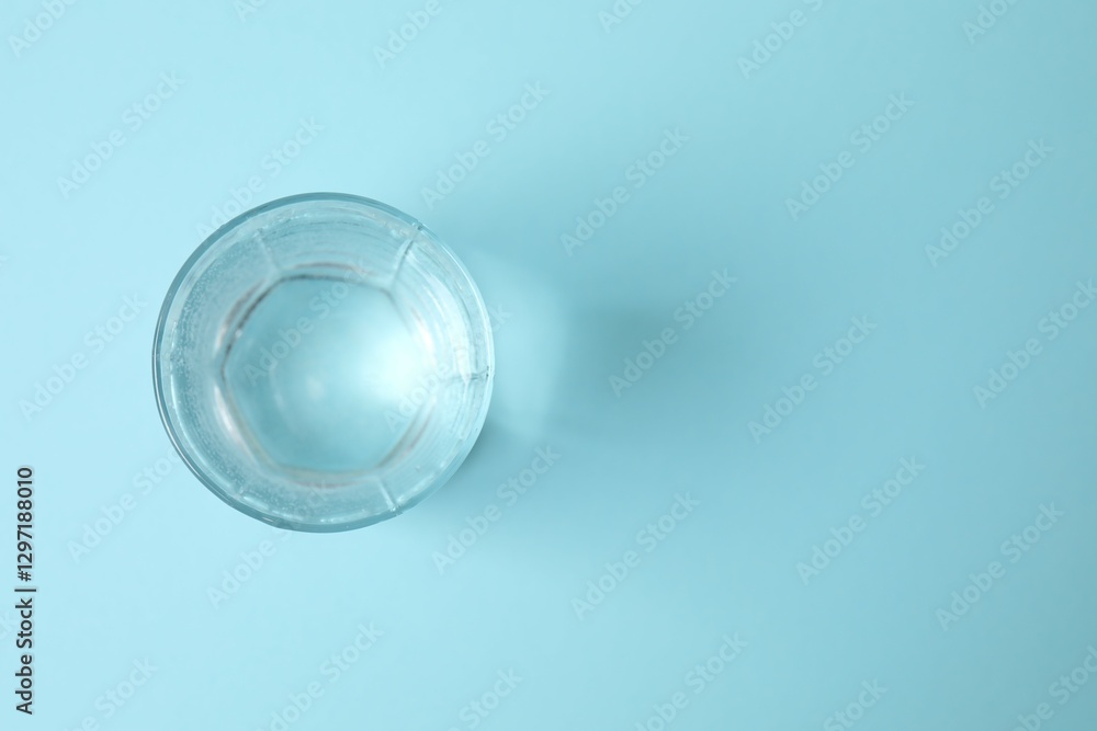 Transparent glass with water on blue background. Drinking clear water in the morning for health Transparent glass with water on blue background. Drinking clear water in the morning for health