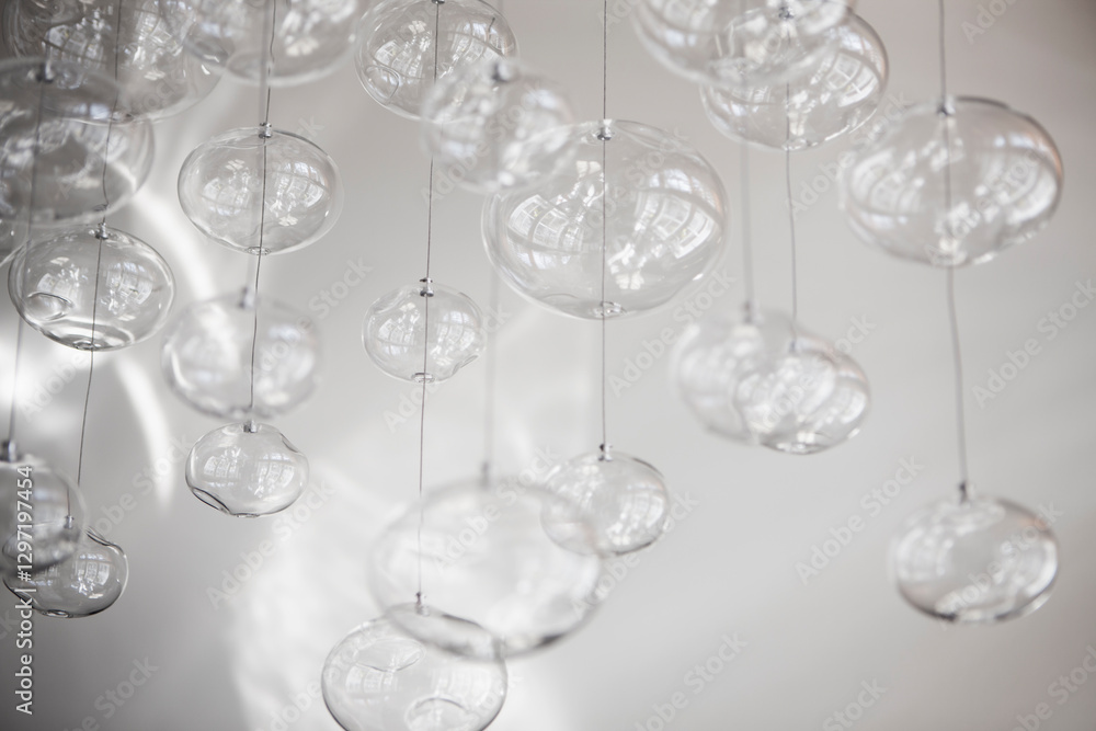 Glass orbs hung up on metal wire from the ceiling, organic forms. Glass orbs hung up on metal wire from the ceiling, organic forms.