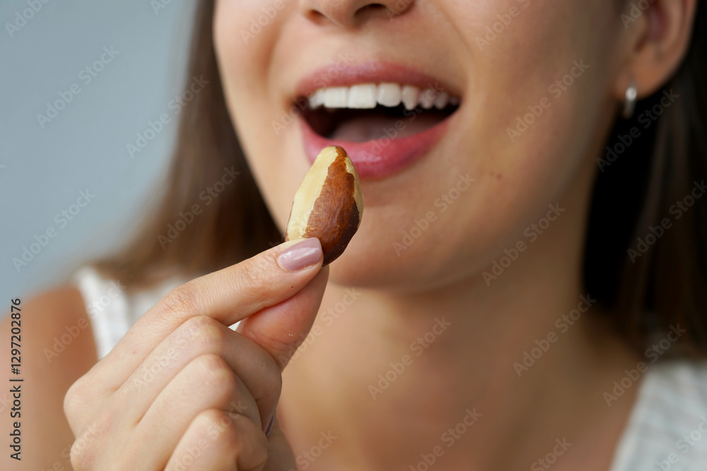 Brazil nuts. Close-up of unidentified girl eating a Brazil nut. Healthy food concept. Brazil nuts. Close-up of unidentified girl eating a Brazil nut. Healthy food concept.