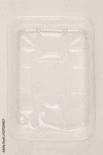 A top-down shot of an empty, clear, plastic food container on a light background