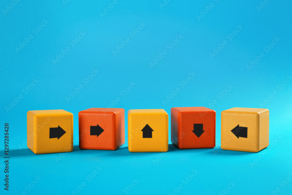 Obraz premium Colorful cubes with arrows pointing in different directions on light blue background