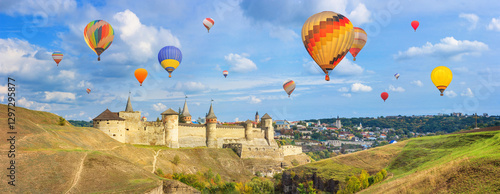 Obraz na płótnie Autumn landscape - view of a medieval fortified castle on a hill with flying the hot air balloons, the town of Kamianets-Podilskyi, Ukraine w salonie