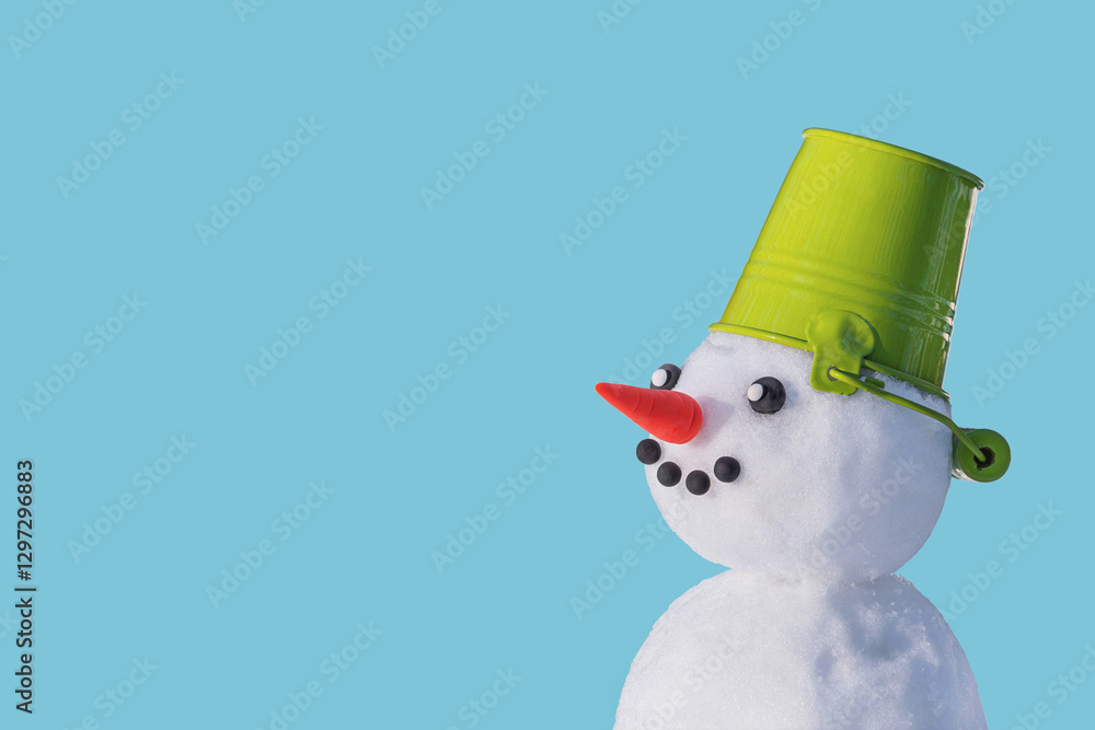 View of the snowman in a hat in the form of a bucket on a blue isolated background. Holiday Christmas winter background