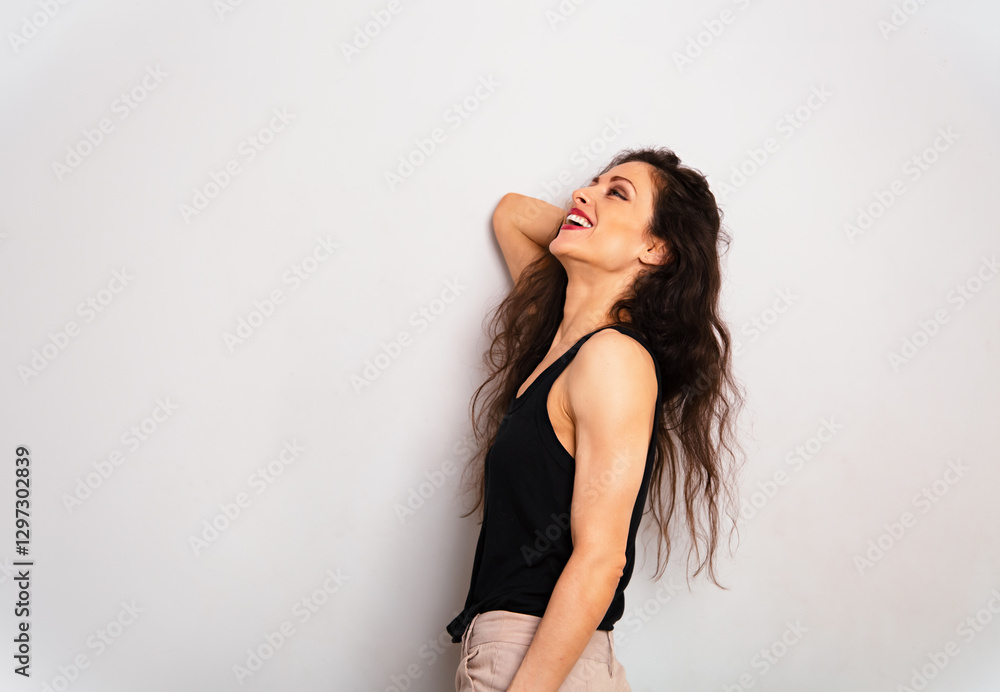 Happy enjoying laughing make-up woman with red lipstick looking up standing in black summer top on blue studio empty copy space background. Expression fun positive portrait Happy enjoying laughing make-up woman with red lipstick looking up standing in black summer top on blue studio empty copy space background. Expression fun positive portrait