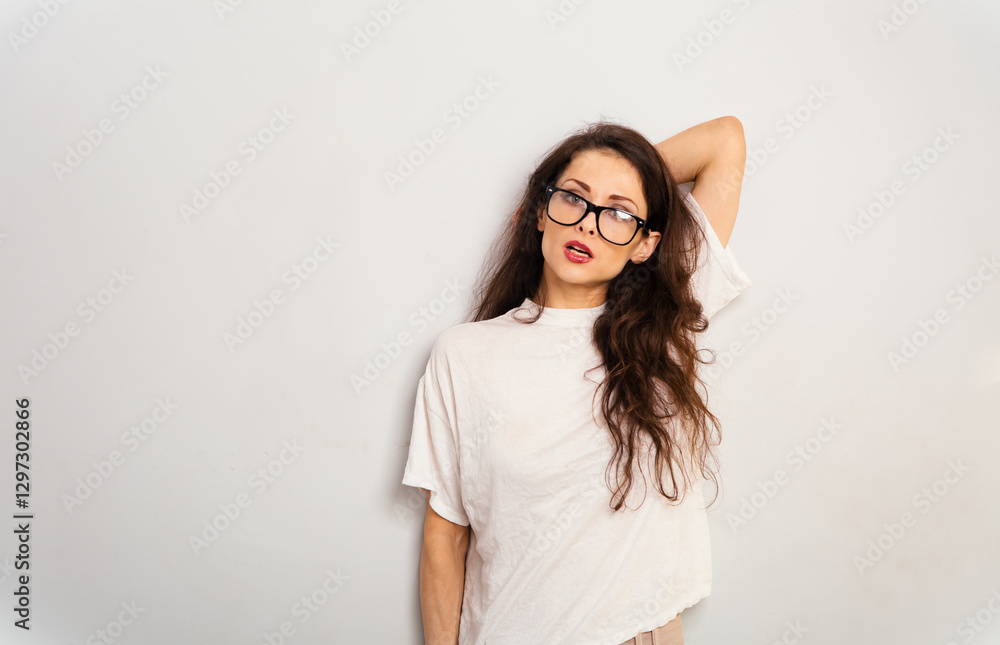 Ambitious serious beautiful brunette woman posing in fashion eyeglasses and white t-shirt and looking on white wall studio background with empty copy space. Banner emotional portrait Ambitious serious beautiful brunette woman posing in fashion eyeglasses and white t-shirt and looking on white wall studio background with empty copy space. Banner emotional portrait