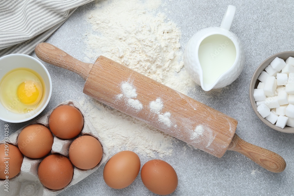 Rolling pin and ingredients for dough on light grey table, flat lay Rolling pin and ingredients for dough on light grey table, flat lay