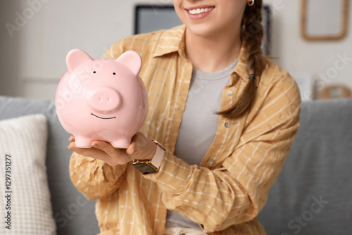 Young woman with piggy bank...