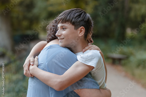 Hug from a happy teenage son to his mother. Tenderness, love, family.