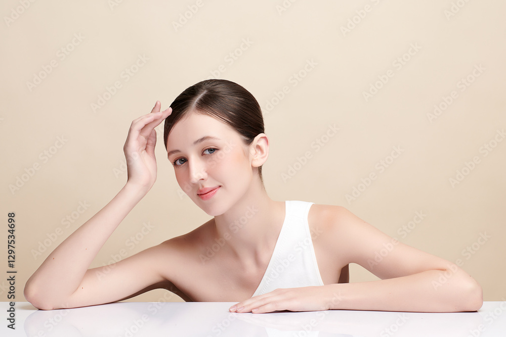 Fototapeta premium Beautiful young woman with clean fresh skin on beige background, Face care, Facial treatment, Cosmetology, beauty and spa, women portrait.